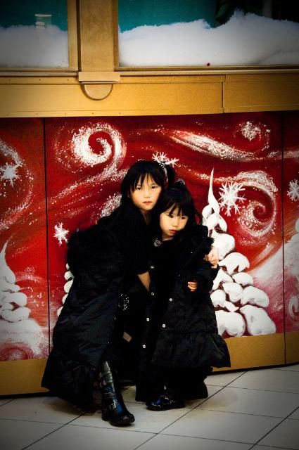 Mon Dec 19,2011, My girls - obliging me one capture in front of a gynormous Christmas display in downtown Montreal.