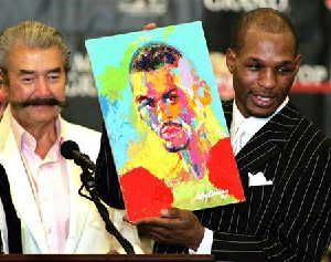 Undisputed middleweight champion Bernard Hopkins (R) holds up a portrait of himself painted by artist LeRoy Neiman (L) during a post-fight press conference at the MGM Grand Garden Arena in Las Vegas, Nevada September 18, 2004.