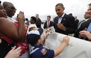 U.S. President Barack Obama signs a book about him for a boy scout upon his arrival in Richmond, Virginia May 5, 2012.