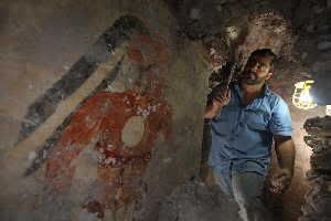 'Younger Brother Obsidian,' as labeled on the north wall of the Maya city’s house by an unknown hand, was painted in the 9th century A.D. Archaeologist William Saturno of Boston University excavates the house in the ruins of the Maya city of Xultun. Younger Brother Obsidian may have been the town scribe. Excavation and preservation of the site were supported by the National Geographic Society. (Credit: Photo by Tyrone Turner (c) 2012 National Geographic)