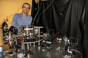 Andrew Geraci, assistant professor in the University of Nevada, Reno physics department, demonstrates an apparatus that is of part of an experiment that uses similar technology to his gravitational wave detector. (Credit: Mike Wolterbeek, University of Nevada, Reno)
