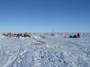 The Pine Island Glacier expedition deployed multiple, unique sensor packages, developed by NPS Research Professor Tim Stanton, through 500 meters of solid ice to determine exactly how quickly warm water was melting the massive glacier from beneath. Pictured is the drill camp at the Pine Island Ice Shelf. The galley is on the left, hot water drill equipment in the center left, surface infrastructure tower mid right, and the seismic sled on the right. (Credit: Image courtesy of Tim Stanton/NPS)