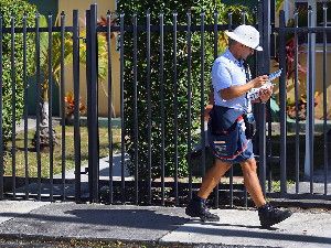 A mailman for the U.S. Postal Service delivers mail on November 15, 2012 in Miami, Florida.