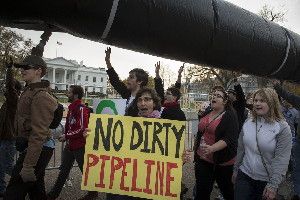 Demonstrators carry a mock pipeline as they pass the White House to protest the Keystone Pipeline, in Washington, D.C., on Nov. 18, 2012.