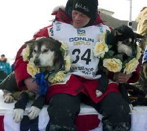 Iditarod winner Dallas Seavey, 25, with two of his dogs, Diesel, left, and Guinness. (Marc Lester / Anchorage Daily News)