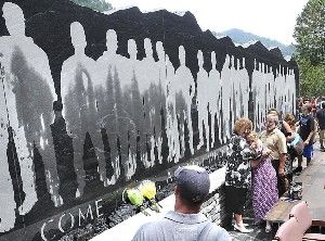 Family and friends view the 48-foot-long granite Upper Big Branch Miners monument, Friday, July 27, 2012 in Whitesville, W.Va, On the heels of a West Virginia coal mining death, families of the 29 men killed in the Upper Big Branch mine dedicated a memorial Friday to their fallen relatives and those injured in the April 2010 explosion. (AP Photo/The Register-Herald, Rick Barbero) Photo: Rick Barbero, Associated Press / SF