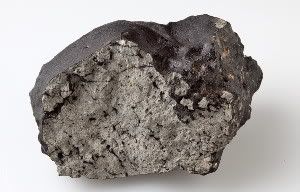 This 1.1-kilogram chunk of the Tissint Martian meteorite shows distinct charring from Earth’s atmosphere and pockets of black glass that contain trapped gas from Mars.