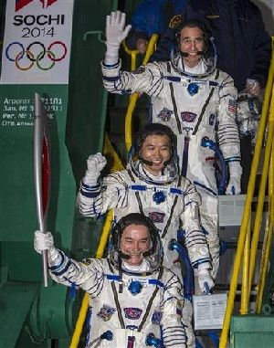 Japanese astronaut Koichi Wakata, center, Russian cosmonaut Mikhail Tyurin, bottom and U.S. astronaut Rick Mastracchio, crew members of the next mission to the International Space Station, pose with an Olympic torch prior the launch of Soyuz-FG rocket at the Russian leased Baikonur cosmodrome, Kazakhstan, Thursday, Nov. 7, 2013. (AP Photo/Shamil Zhumatov, Pool)
