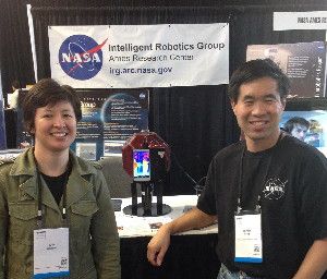Research engineer D.W. Wheeler and Terry Fong, NASA's director of the Intelligent Robotics Group, flank the SPHERES utility robot with the Project Tango smartphone mounted on the side.