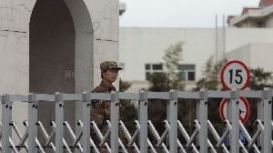 A Chinese soldier stands guard Tuesday in front of the Shanghai building that houses military Unit 61398. A U.S. cybersecurity company says the unit is behind nearly 150 computer attacks on U.S. and other Western companies and organizations in recent years. China denies the allegation.
