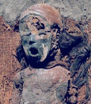 A 4,500-year-old Chinchorro mummy. The body has been painted with red ochre and wears a long human-hair wig.