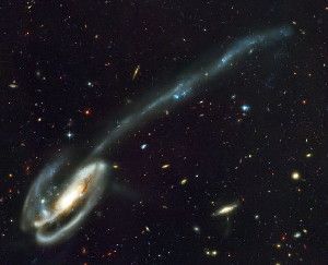 This image shows the Tadpole galaxy (Arp 188), a disrupted barred spiral galaxy located 420 million light-years from our planet. Material stripped from the galaxy during its collision with a smaller galaxy (seen in the upper left corner of the larger interaction partner) forms a long tidal tail. Young blue stars, star clusters and tidal dwarf galaxies are born in the tidal debris. These objects move in a common direction within a plane defined by the orientation and motion of their tidal tail. A similar galaxy interaction might have occurred in the Local Group in the past, which could explain the distribution of dwarf galaxies in co-rotating planes. Image credit: H. Ford, JHU / M. Clampin, STScI / G. Hartig, STScI / G. Illingworth, UCO, Lick / ACS Science Team / ESA / NASA.