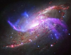 This composite image of galaxy NGC 4258 shows the galaxy’s unusual two extra spiral arms, with X-rays from NASA’s Chandra X-ray Observatory in blue, radio data from the National Science Foundation’s Karl Jansky Very Large Array in purple, optical data from NASA’s Hubble Space Telescope in yellow and infrared data from NASA’s Spitzer Space Telescope in red. (X-ray: NASA/CXC/Caltech/P.Ogle et al; Optical: NASA/STScI; IR: NASA/JPL-Caltech; Radio: NSF/NRAO/VLA)