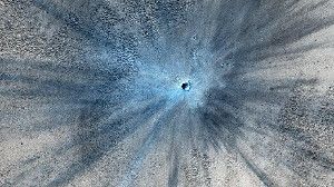 An enhanced image of a newly formed crater on Mars. The feature, including the ejected material, stretches more than 9 miles across.
