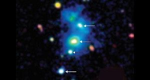 QUADRUPLETS &nbsp;Four quasars (marked with arrows) lie within a nebula (blue) that stretches 1 million light-years across in this false color image.
