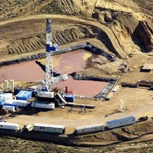 Aerial view showing typical drilling activity in the Pinedale Anticline natural gas field of Wyoming. Drilling fluids (reddish-brown) are being expelled into open pits.