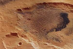 Image Caption: This computer-generated perspective view was created using data obtained from the High- Resolution Stereo Camera (HRSC) on ESA’s Mars Express. Centered at around 7°N and 353°E, this image has a ground resolution of about 26 m per pixel. A part of Danielson crater dominates this view with the detailed relief of the yardangs being interrupted by the 30 km-long field of dark dunes. The uniform thickness in the alternating sedimentary layers provides evidence for the theory that periodic changes in the climate of Mars occurred, possibly due to changes in the planet’s rotation axis. Credits: ESA/DLR/FU Berlin (G. Neukum)