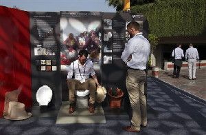 In this Friday, March 21, 2014 photo, an exhibitor from Loughborough University demonstrates the use of a toilet during Reinvent The Toilet Fair in New Delhi, India. Scientists who accepted the Bill & Melinda Gates Foundation's challenge to reinvent the toilet showcased their inventions in the Indian capital Saturday. The primary goal: to sanitize waste, use minimal water or electricity, and produce a usable product at low cost. India is by far the worst culprit, with more than 640 million people defecating in the open and producing a stunning 72,000 tons of human waste each day - the equivalent weight of almost 10 Eiffel Towers or 1,800 humpback whales. (AP Photo/Tsering Topgyal)