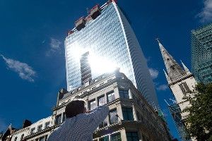 A man reacts to a shaft of intense sunlight reflected from the glass windows of the 'Walkie Talkie' tower in central London.